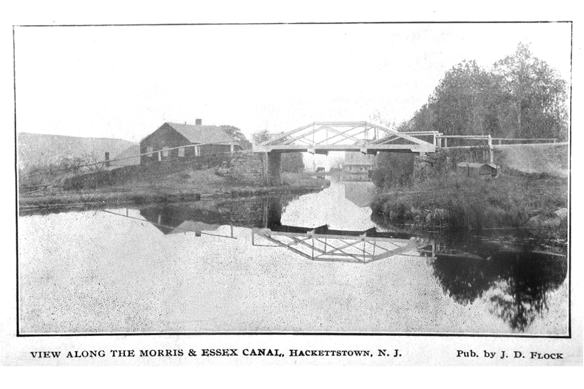 Looking west under the Main Street (Rte 46) bridge in Hackettstown, we see the Mitchell/Harvey canal store in the distance. The dark colored building was a canal warehouse.