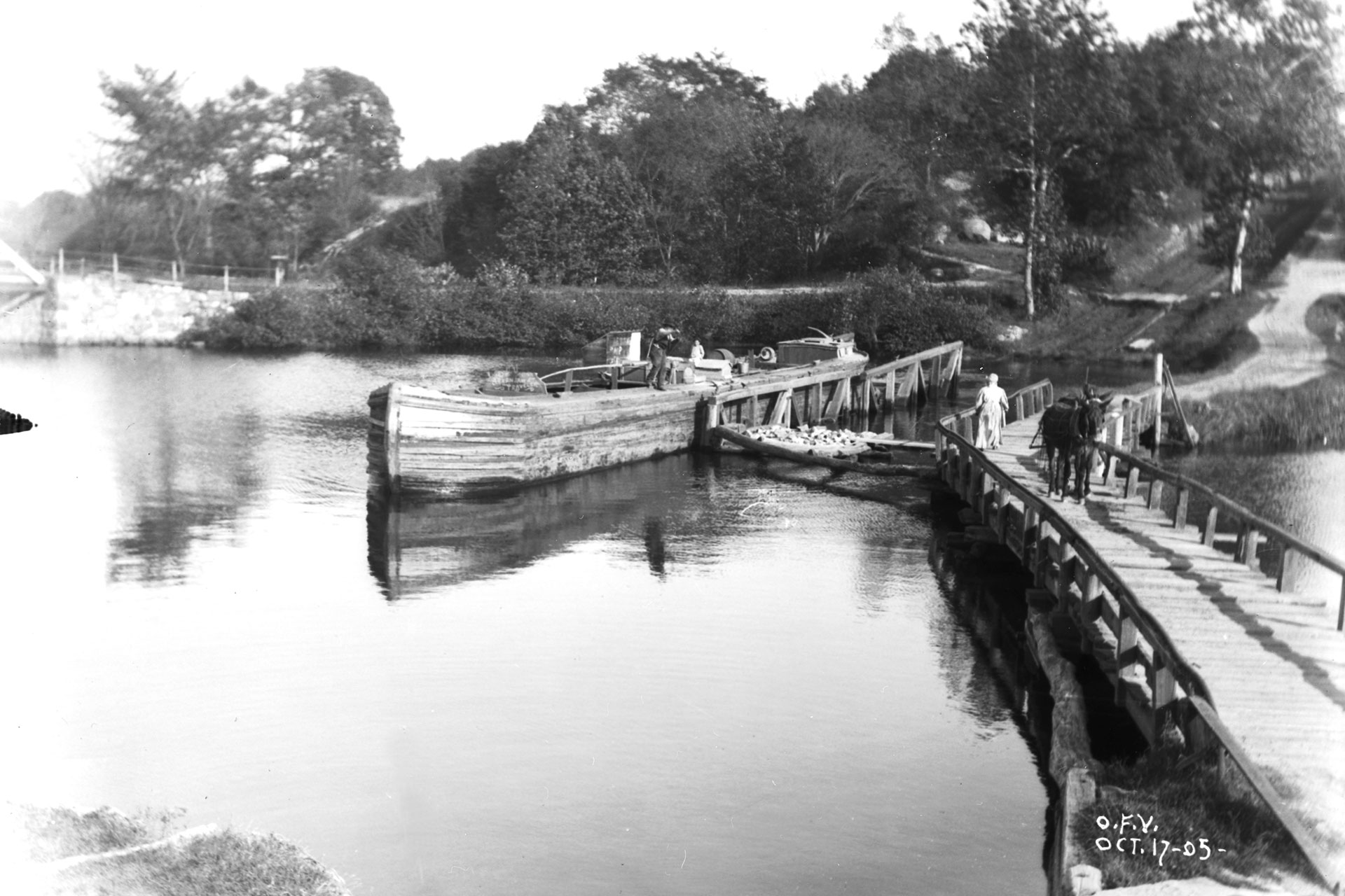 A boat has just descended Plane 4 West and is making its way across the Musconetcong River to Waterloo village.