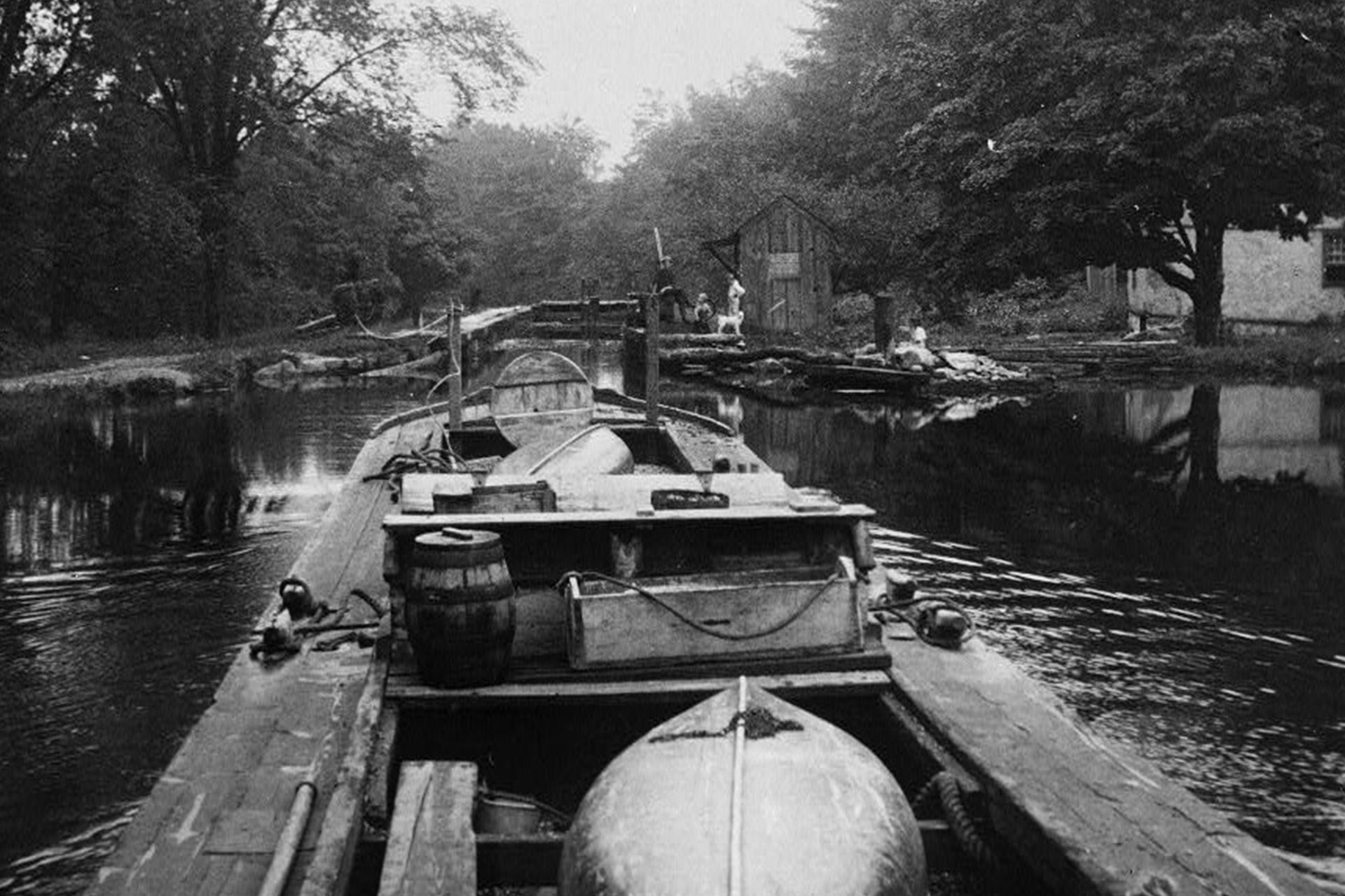 This photo of a canal boat approacing Lock 2 East in Wharton provides a good view of what a captain would have onboard. Visible are a tool box, fresh water barrel, and open stove. Two small boats serve as additional cargo.