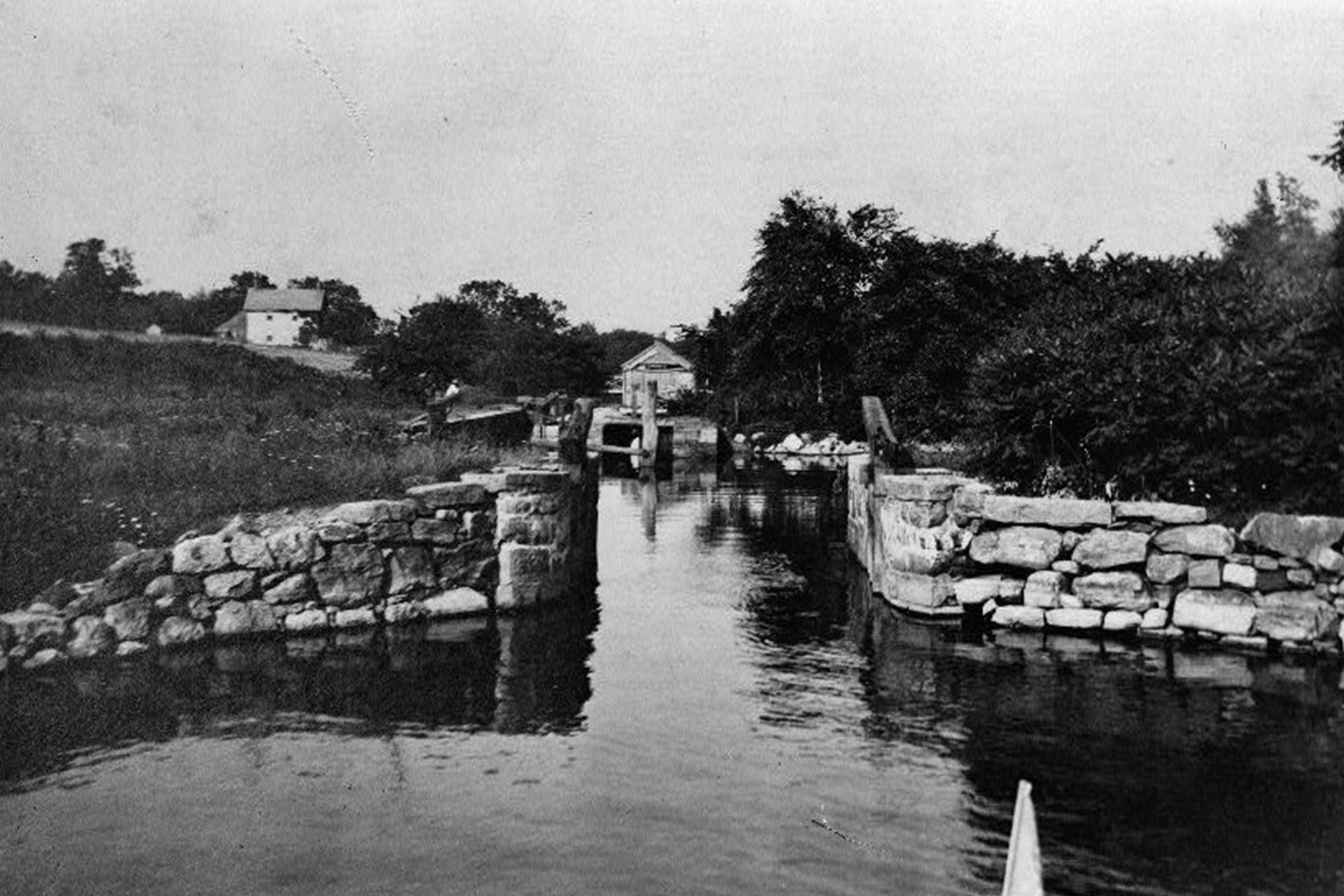 A boat approaches the outer stop gates on Lake Hopatcong, and will soon pass through Brooklyn Lock. The white building seen in the distance left of center was the tender’s house, and is now the Lake Hopatcong Historical Museum.