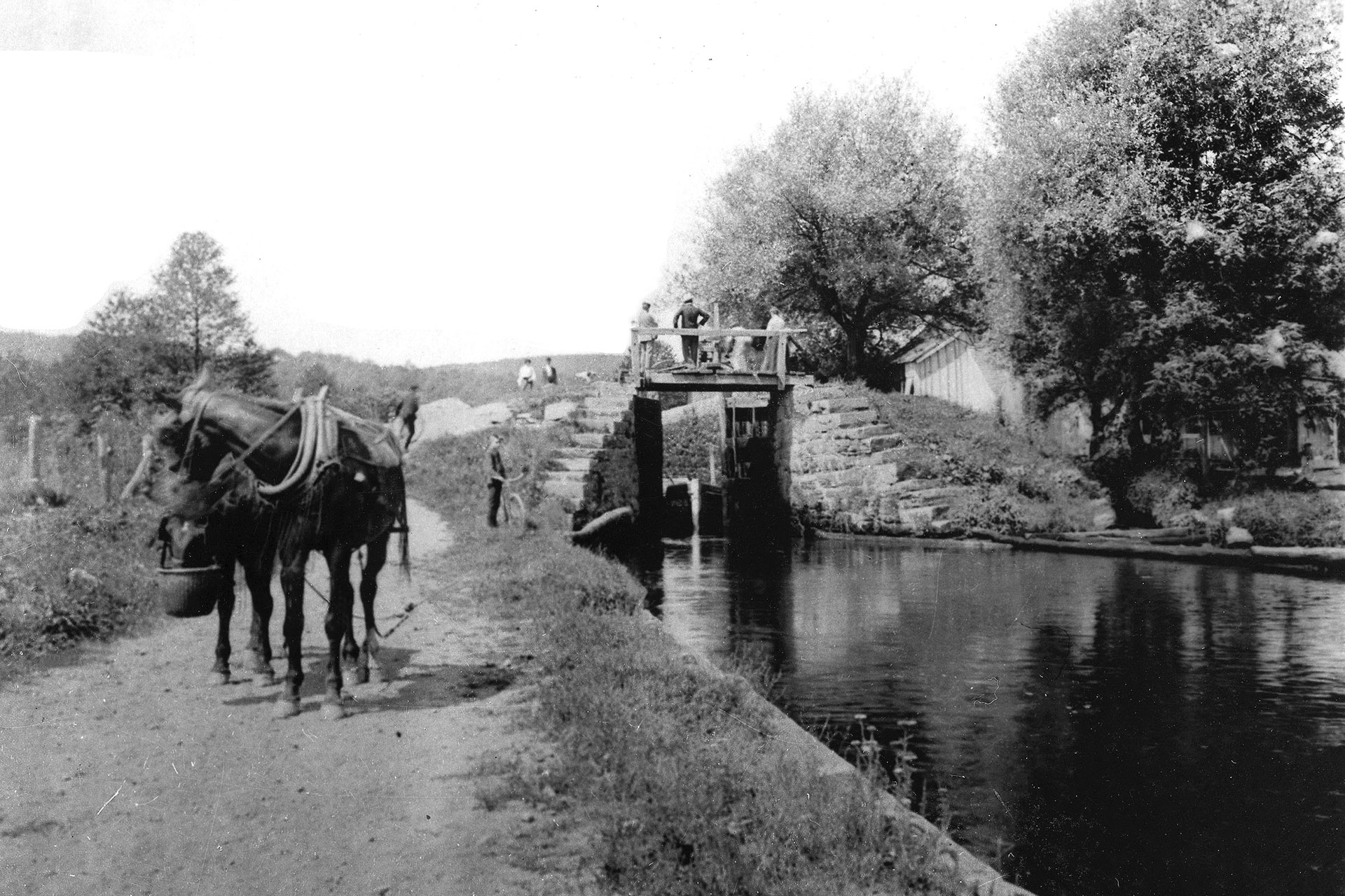 A mule team takes a lunch break while a canal boat exits the foot of Lock 1 East in Ledgewood. The tender’s house is on the right.