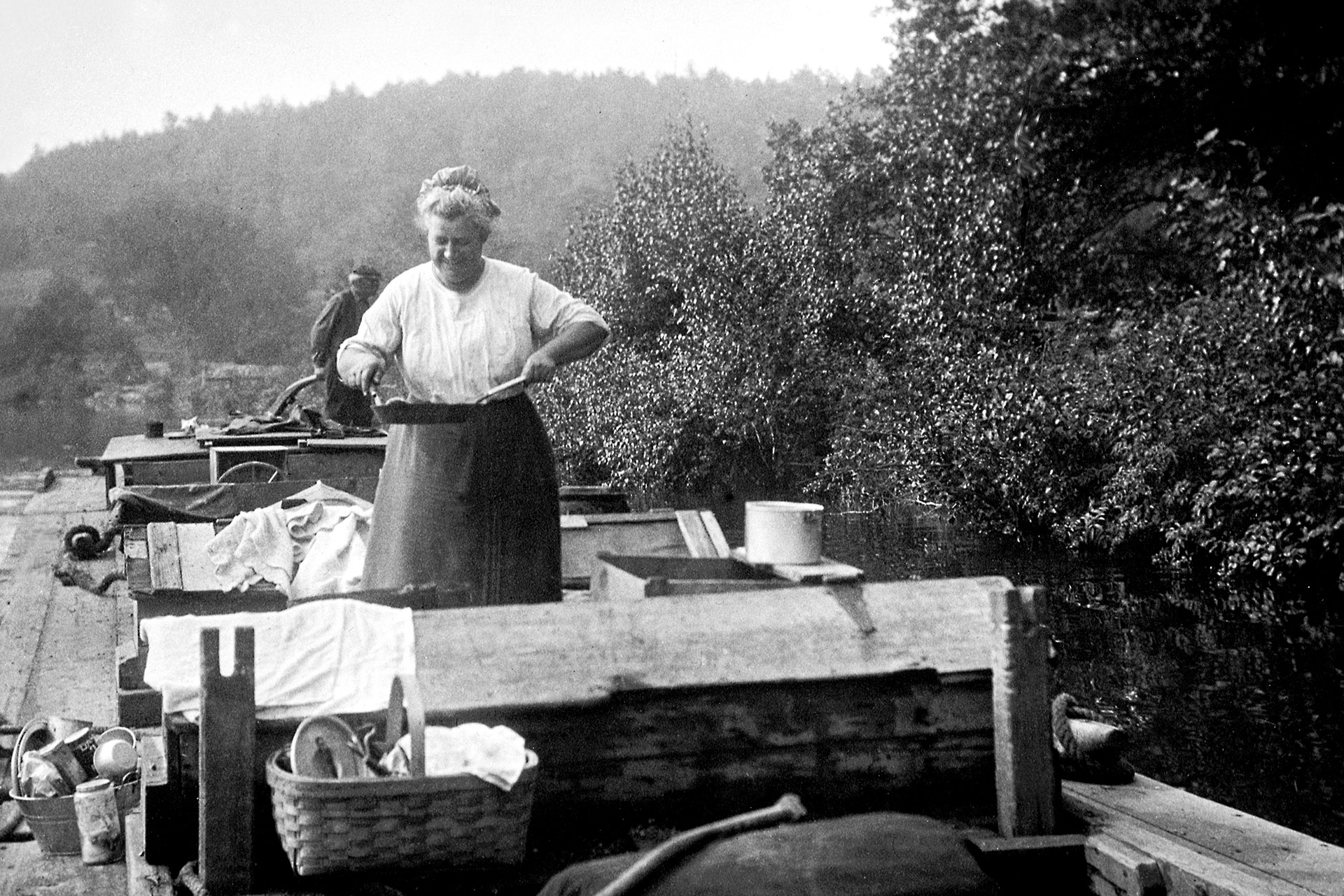 Life on the Morris Canal lasted 9 months of the year. Here a woman is seen cooking a meal as her husband helms the boat. Laundry is seen drying on the mule feed boxes.